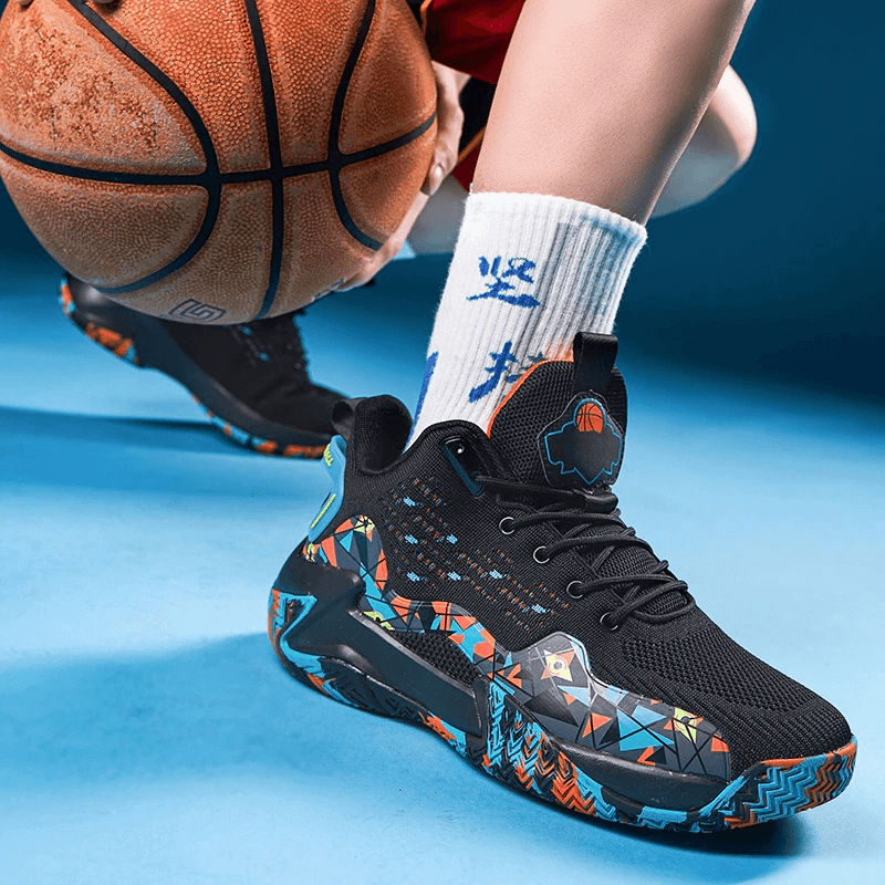 Black breathable mesh sports shoes with colorful pattern, featuring cushioning and rubber outsole, next to a basketball on blue floor.
