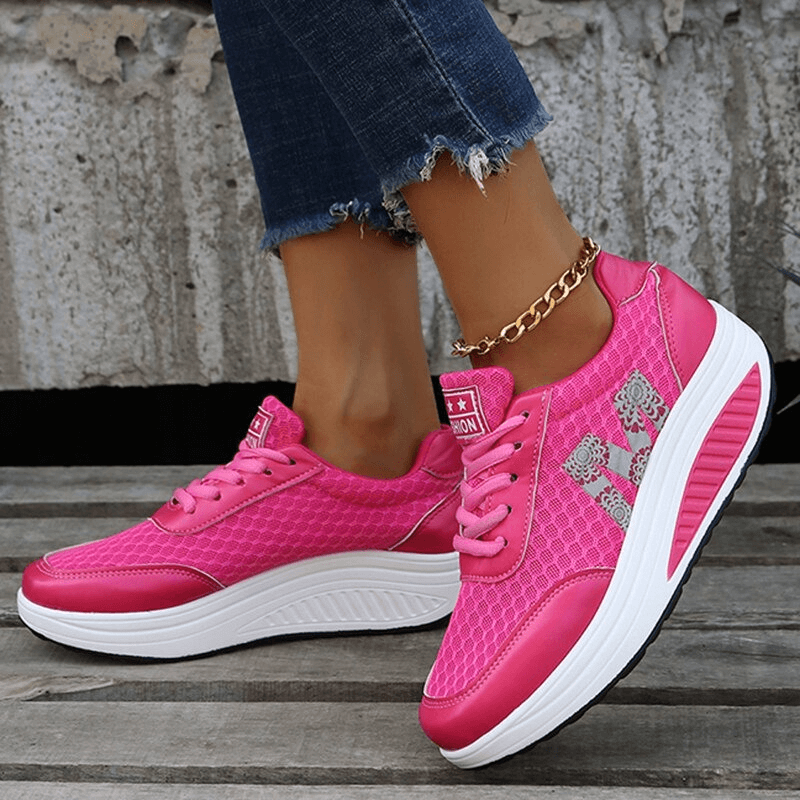 Woman wearing pink breathable mesh thick-bottom sneakers with lace-up design. Casual shoes SF0262 for stylish comfort.