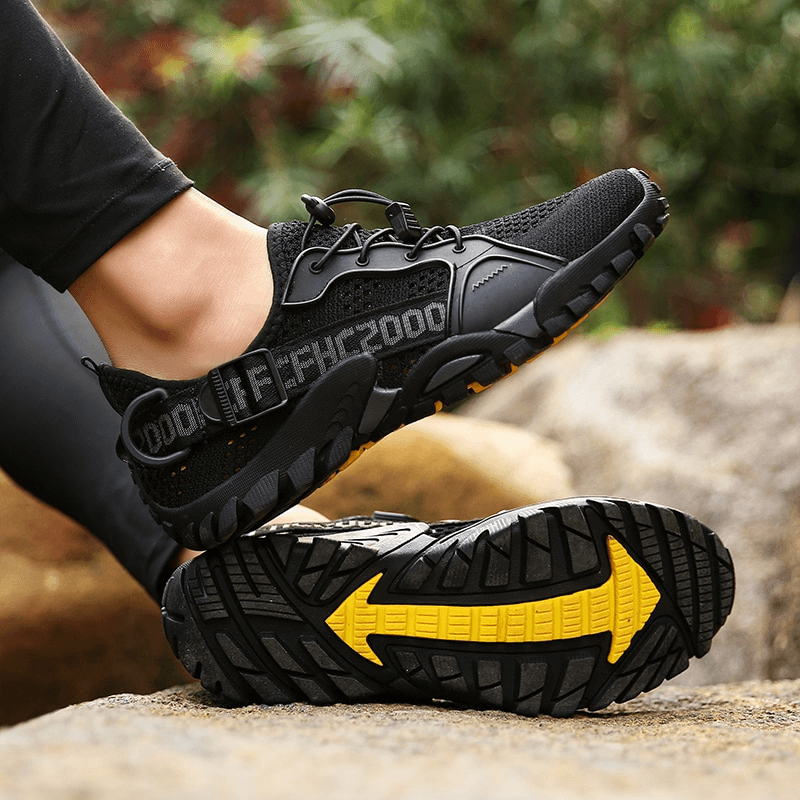 Black breathable mesh trekking shoes with yellow tread on rubber outsole, perfect for outdoor adventures and sports. Unisex design SF0756.
