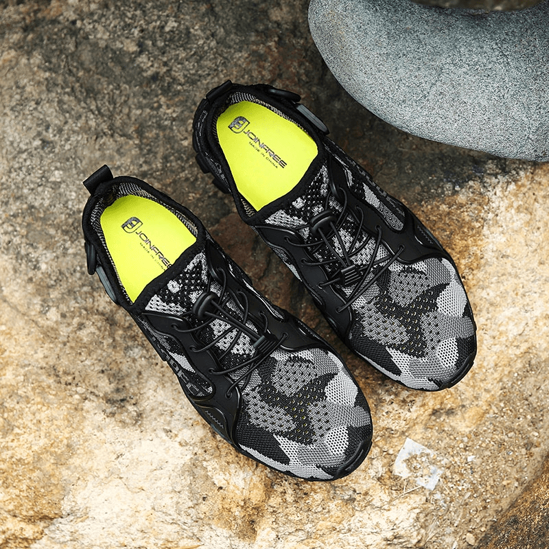 Stylish unisex breathable mesh trekking shoes on rock surface, perfect for hiking and outdoor sports adventures with excellent traction.