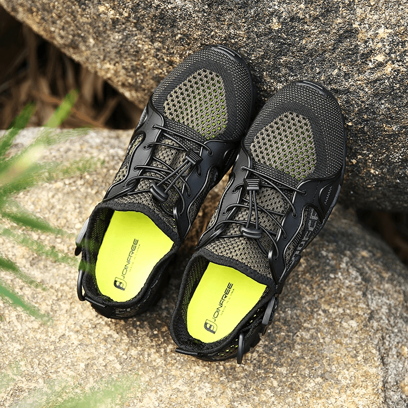 Breathable mesh trekking shoes SF0756 with rubber outsole for outdoor adventures, unisex sports sneakers on rocky surface.