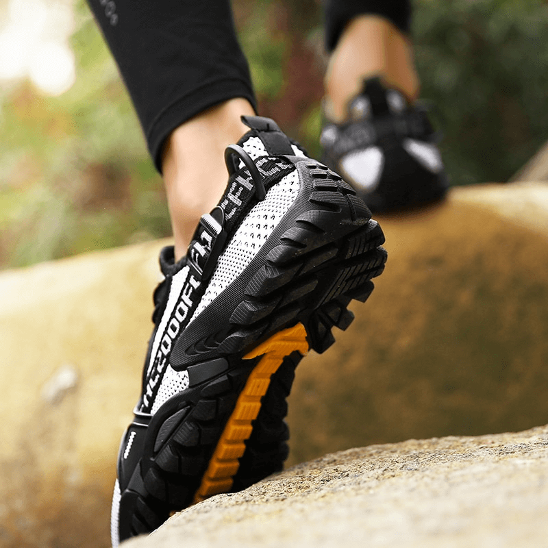 Close-up of breathable mesh trekking shoes with rubber sole for outdoor adventures, showcasing excellent traction and stylish design.