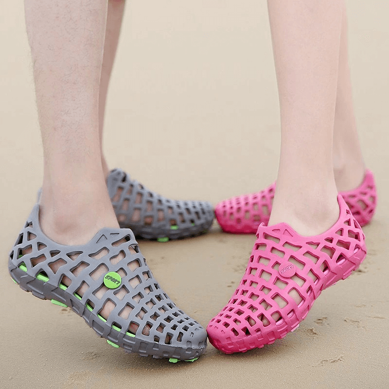 Unisex breathable rubber beach slippers in pink and gray, perfect for outdoor activities and everyday wear, shown on sandy beach.