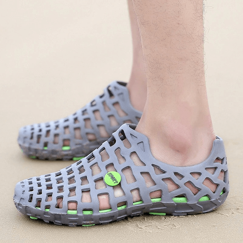 Unisex breathable rubber beach slippers, perfect for water activities, with synthetic uppers and durable rubber soles, shown on sand.