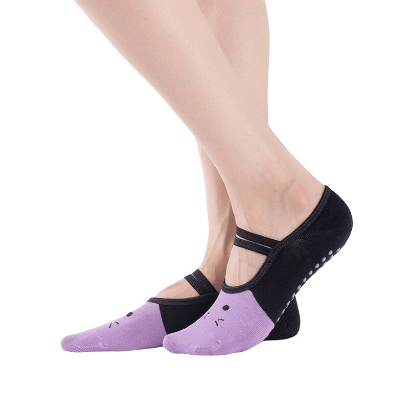 Woman wearing cartoon cat print anti-slip yoga socks, purple and black design for stability and comfort during workouts.