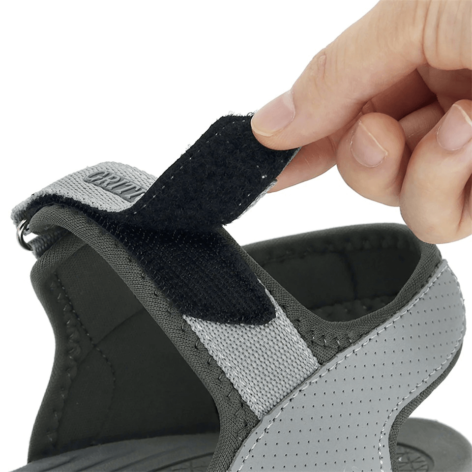 Close-up of a person's hand adjusting the hook & loop closure on Casual Closed Toe Flat Heels Women's Sandals, gray color, style SF0269.