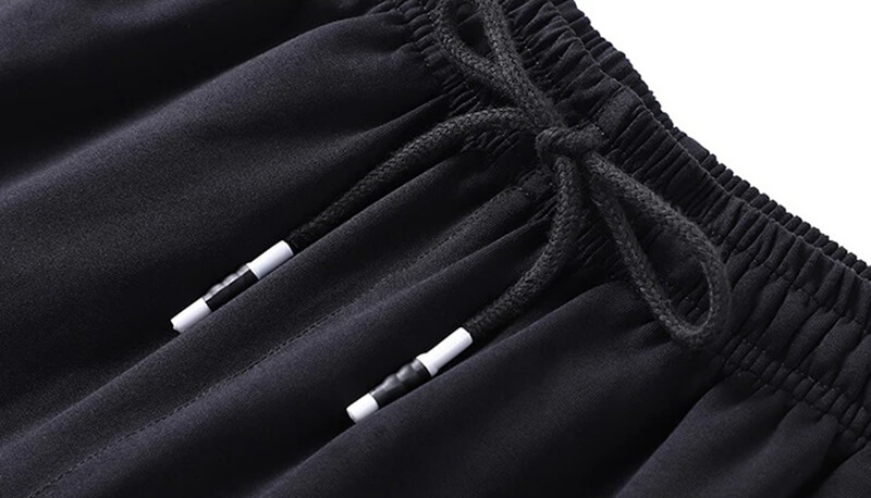 Close-up of black elastic waist casual cotton sweatpants with drawstring closure for men, featuring durable materials and stylish design.