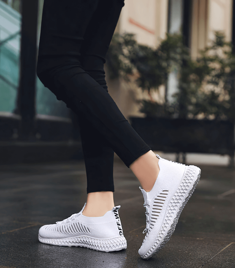 Woman walking in white mesh breathable sneakers SF0265 with lace-up flat bottom, perfect for casual use and comfort.