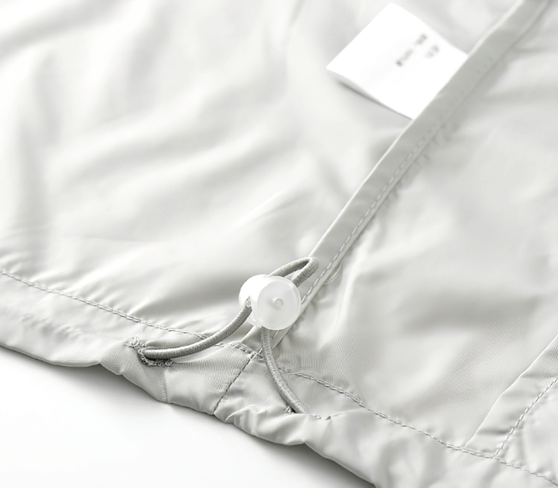 Close-up of the light gray Casual Breathable Hooded Patchwork Jacket, showcasing its drawstring and zipper detail, perfect for summer wear.