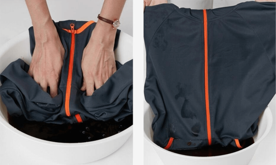 Hand washing a casual lightweight, waterproof sunscreen jacket for men in a basin.