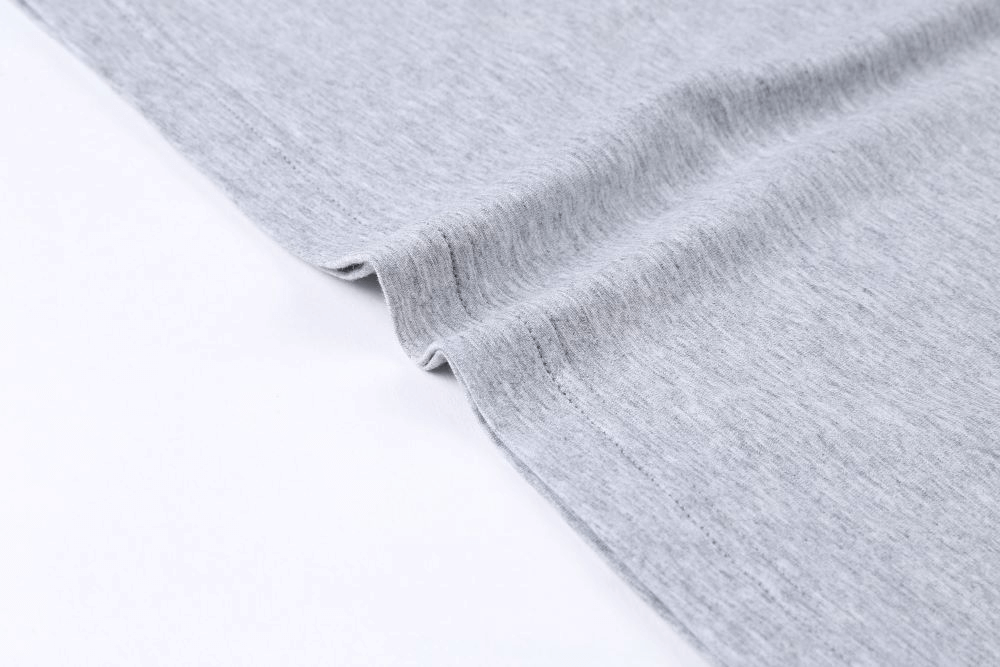 Close-up of soft gray cotton fabric showcasing texture and quality for a casual male V-neck T-shirt with striped sleeves.