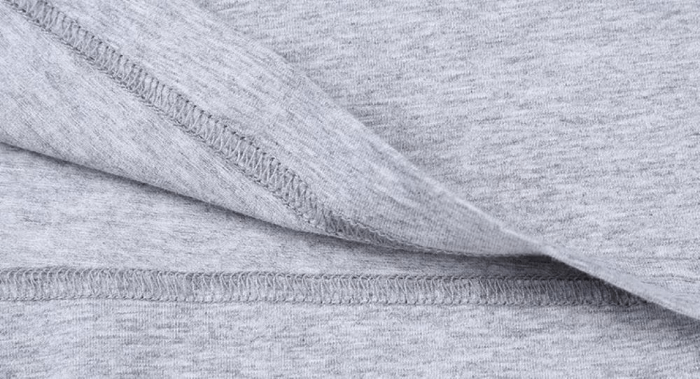 Close-up of soft cotton fabric texture in light gray, highlighting fine stitching and breathable knit, ideal for casual wear.