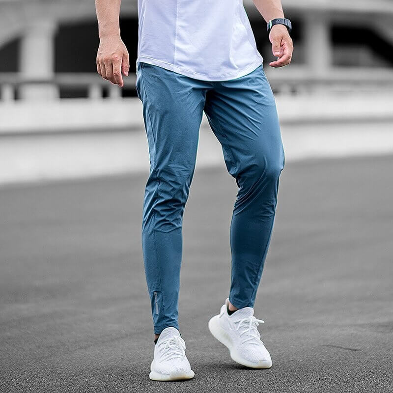 Casual male long sweatpants in blue for running, featuring full-length design and elastic waist, ideal sports workout trousers.