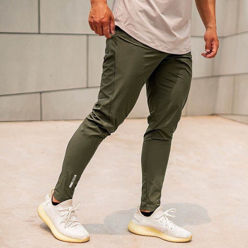 Casual male long sweatpants, olive green, perfect for running; made of polyester and spandex with an elastic waist for comfort.