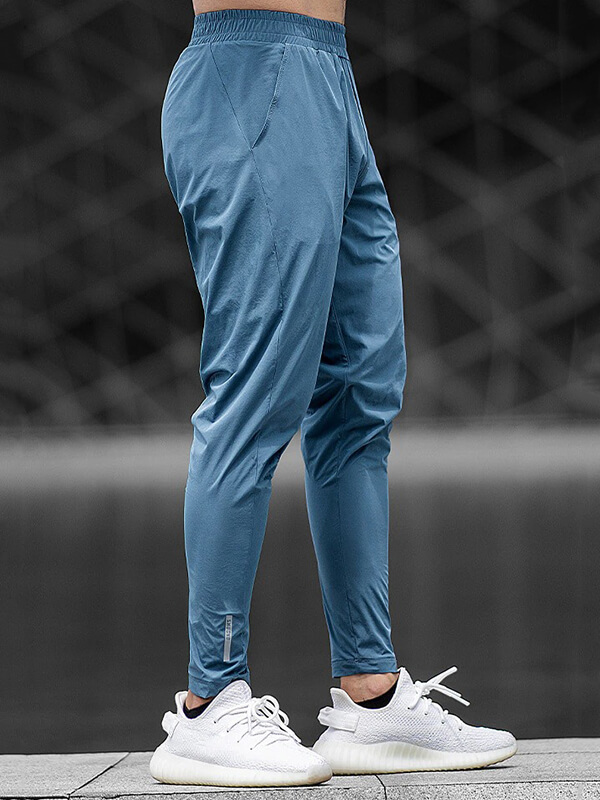 Casual male long sweatpants for running, shown in blue with elastic waist, ideal for workouts. Polyester and spandex blend.