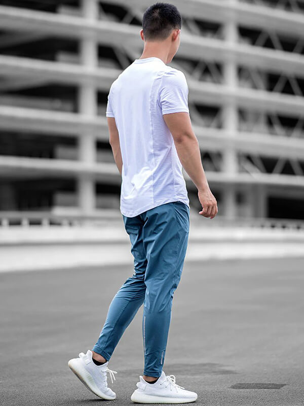 Man wearing casual male long sweatpants, perfect for running, made from polyester and spandex, with an elastic waist.