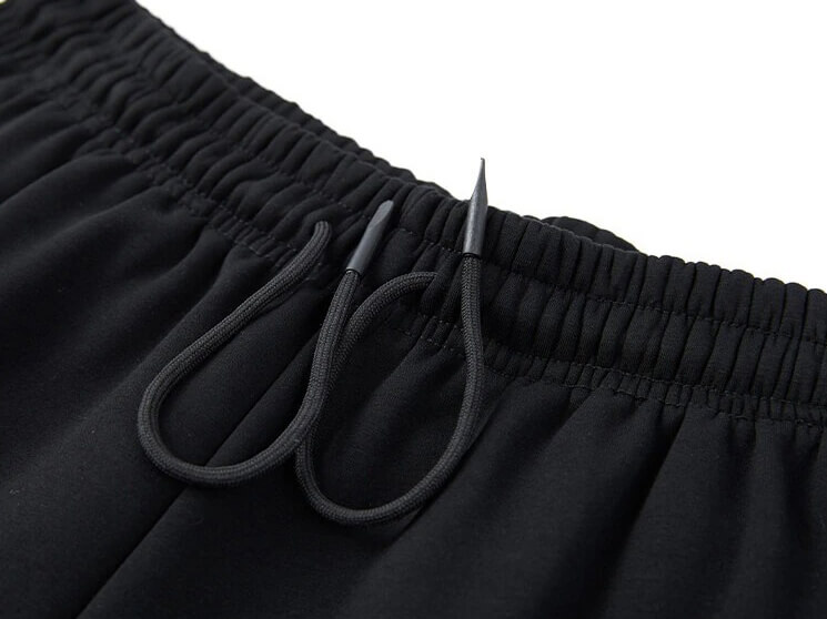 Close-up of black drawstring waistband on men's windproof warm sportswear pants.