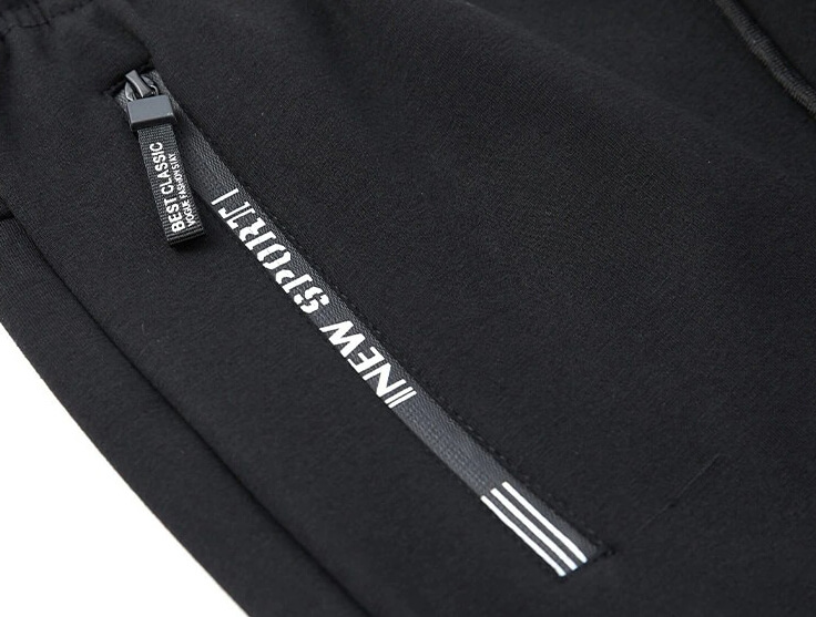 Close-up of black windproof warm sportswear pants with side zipper and "New Sport" detailing for casual men's wear.