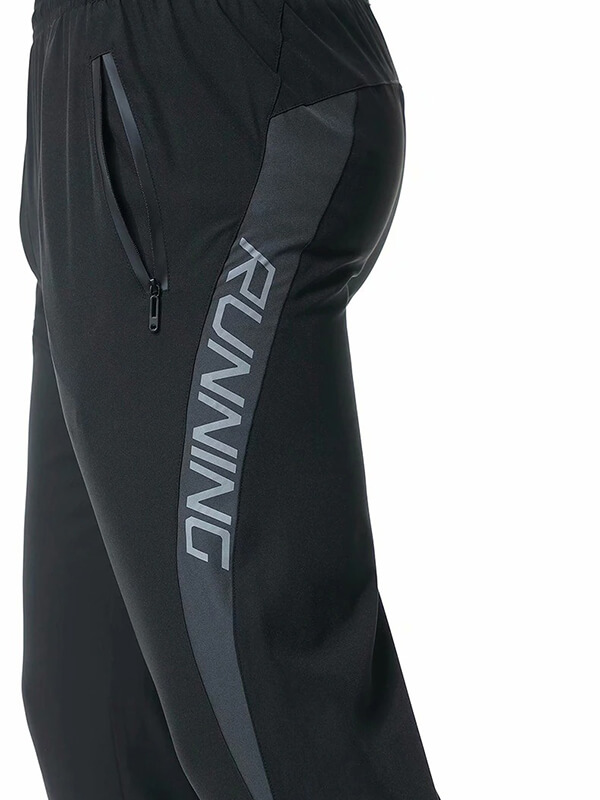 Close-up of black casual running joggers for men featuring a zipper pocket and 'RUNNING' print on the side.
