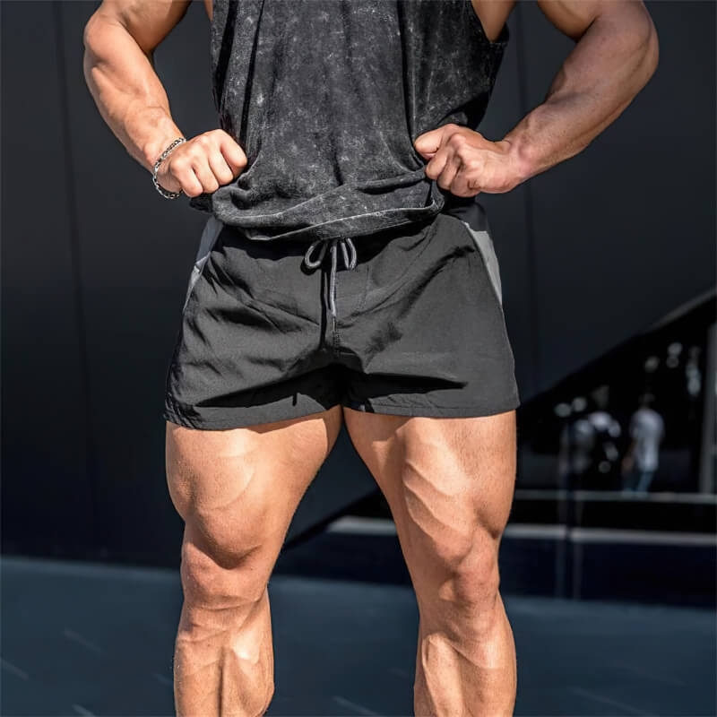 Man wearing black casual training drawstring short shorts, showcasing athletic build, designed for performance and breathability.