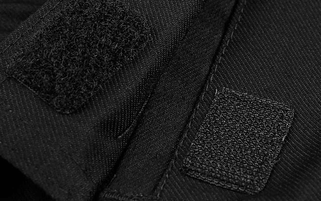 Close-up of black waterproof trekking trousers with Velcro closure detail for women, highlighting durability and design.