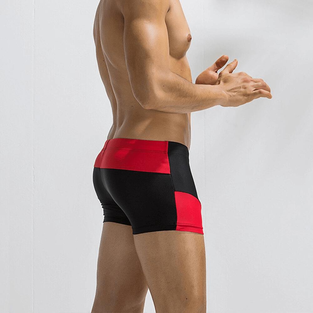 Model wearing color block swimming boxer shorts for men with red and black design, showcasing sleek fit and elastic comfort.