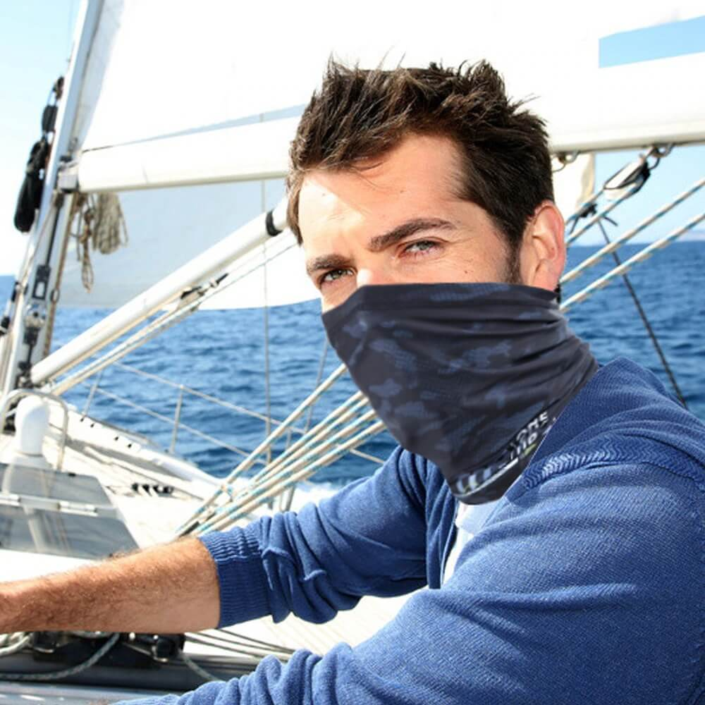 Man sailing wearing Cool Sports Printed Neck Gaiter for sun protection during outdoor adventure.