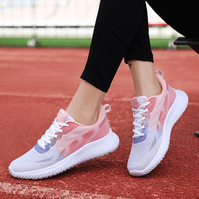 Woman wearing Doble Color Breathable Running Shoes, Women's Fitness Footwear, showcasing mesh design on a running track.