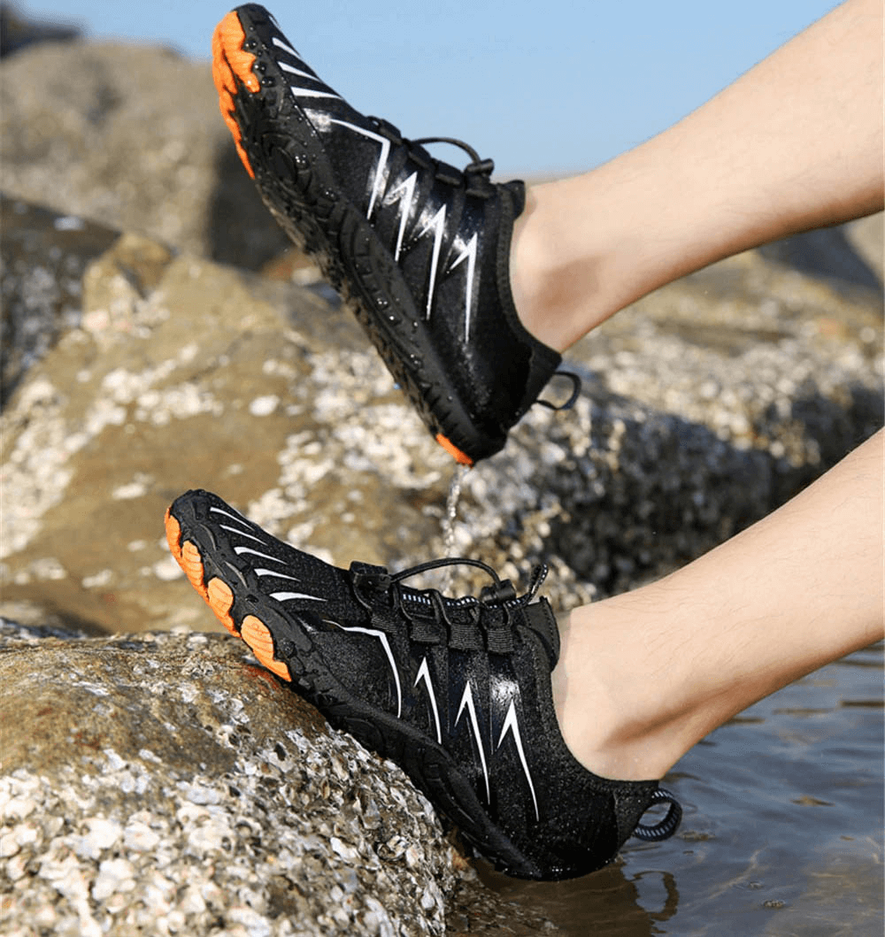 Drainage antiskid sole breathable swimming shoes worn near water on rocks showcasing slip-resistant features.