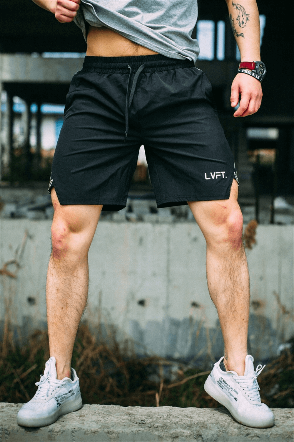Man wearing black drawstring running shorts, ideal for gym and fitness, standing confidently outdoors.