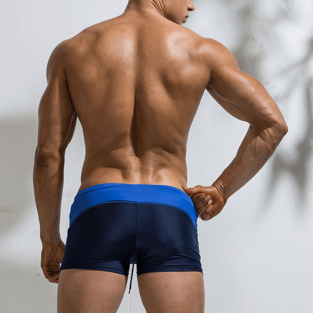 Back view of a man wearing blue Elastic Beach Men's Swimming Trunks, showcasing the elastic waistband and durable polyester fabric.