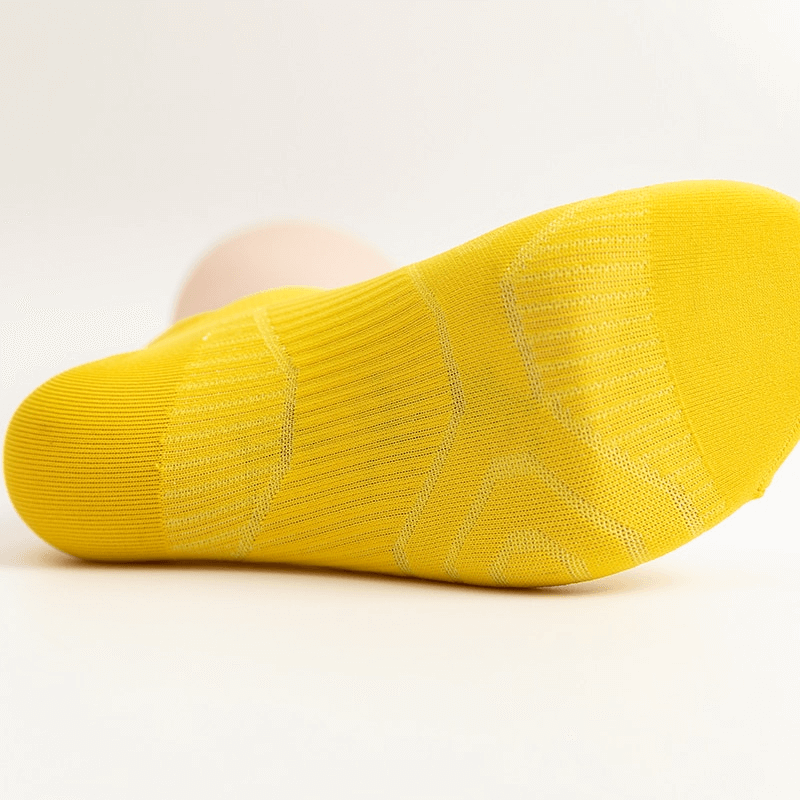 Yellow elastic breathable unisex ankle sock showcasing cushioned sole and ribbed texture for comfort and durability.