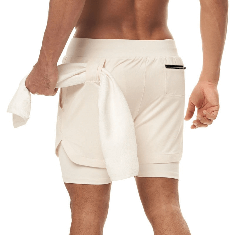Back view of man wearing beige elastic fitness running double shorts with phone pocket, ideal for intense workouts and bodybuilding.