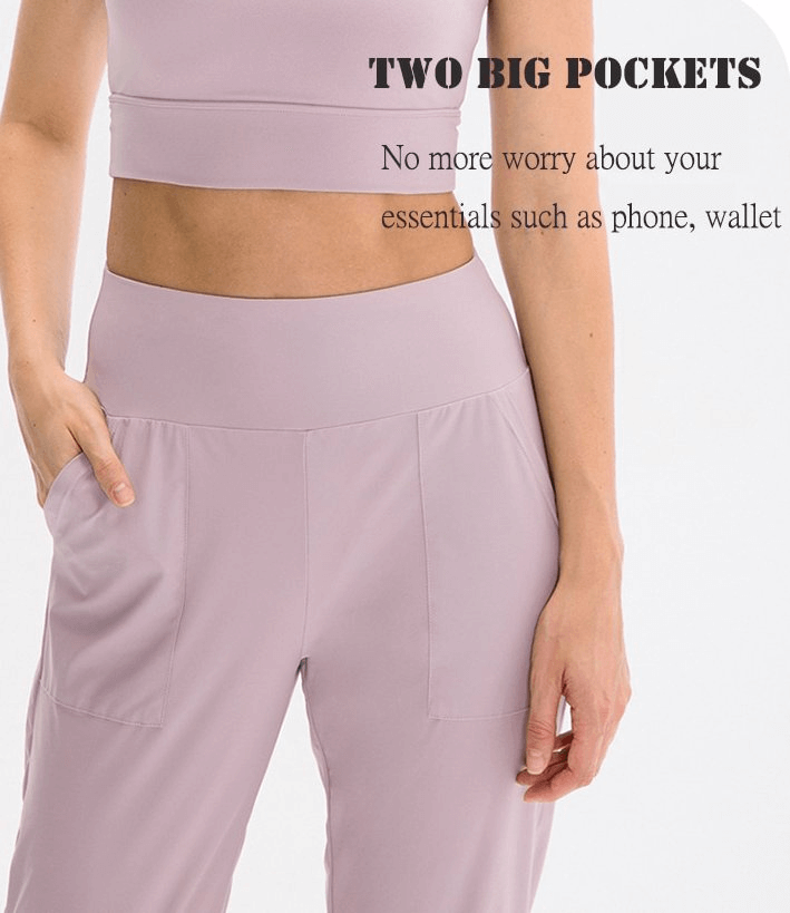Model wearing light pink elastic women's sweatpants with two large side pockets, ideal for yoga and outdoor activities.