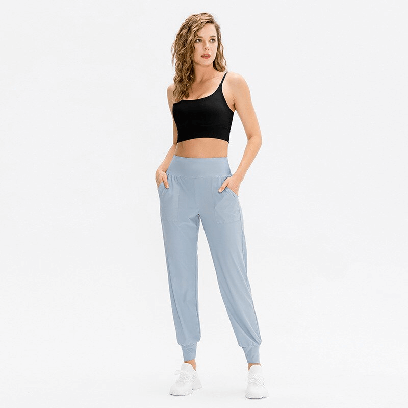 Woman wearing elastic lightweight sweatpants with pockets, ideal for yoga or outdoor activities, shown in full-length view.