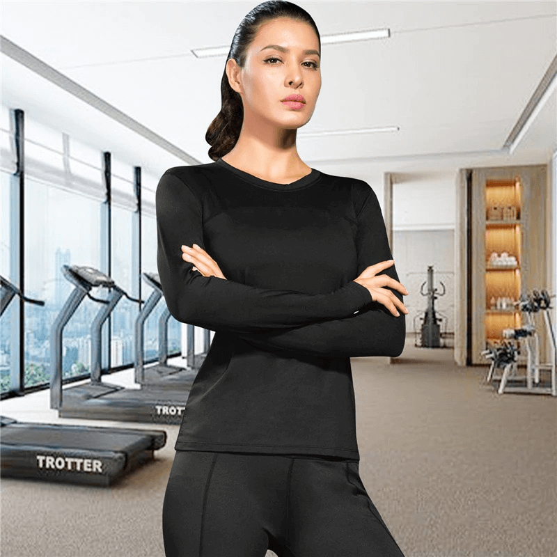 Woman in black elastic long sleeve running top, standing confidently in a gym setting. Ideal for workouts, yoga, and exercise.