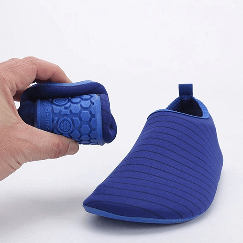 Blue quick-drying water shoes with stretch fabric and rubber sole, showing flexibility and grip, perfect for beach adventures.