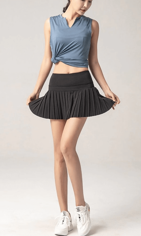 Woman wearing elastic pleated skirt-shorts in black, perfect for yoga and fitness, showcasing stylish sportswear with slim fit and comfort.