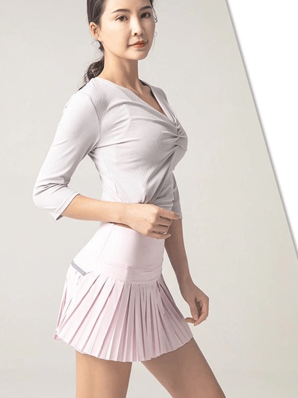 Woman wearing elastic pleated skirt-shorts, ideal for yoga, running, and fitness. Sportswear by Women's Sportswear, lightweight and breathable.