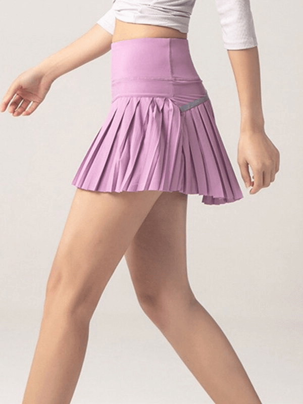 Woman wearing a stylish pink elastic pleated skirt-shorts, ideal for yoga and fitness, showcasing comfort and style in sportswear.