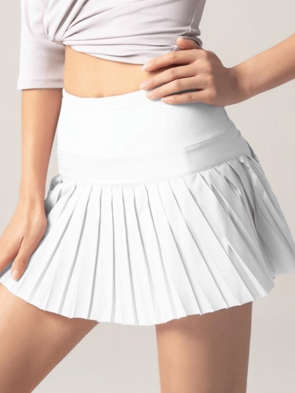 Woman wearing a stylish white elastic pleated skirt-shorts, perfect for sports and casual wear, featuring a slim fit and breathable fabric.