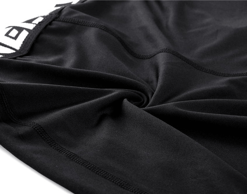 Close-up of black elastic men's running pants with breathable fabric and modern design.