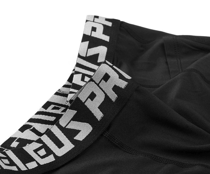 Close-up of black elastic running training men's pants with branded waistband, designed for comfort and style during sports activities.