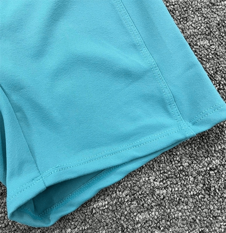 Close-up of blue elastic sports short, women's open-back jumpsuit fabric, highlighting breathable and stretchy material for workouts.