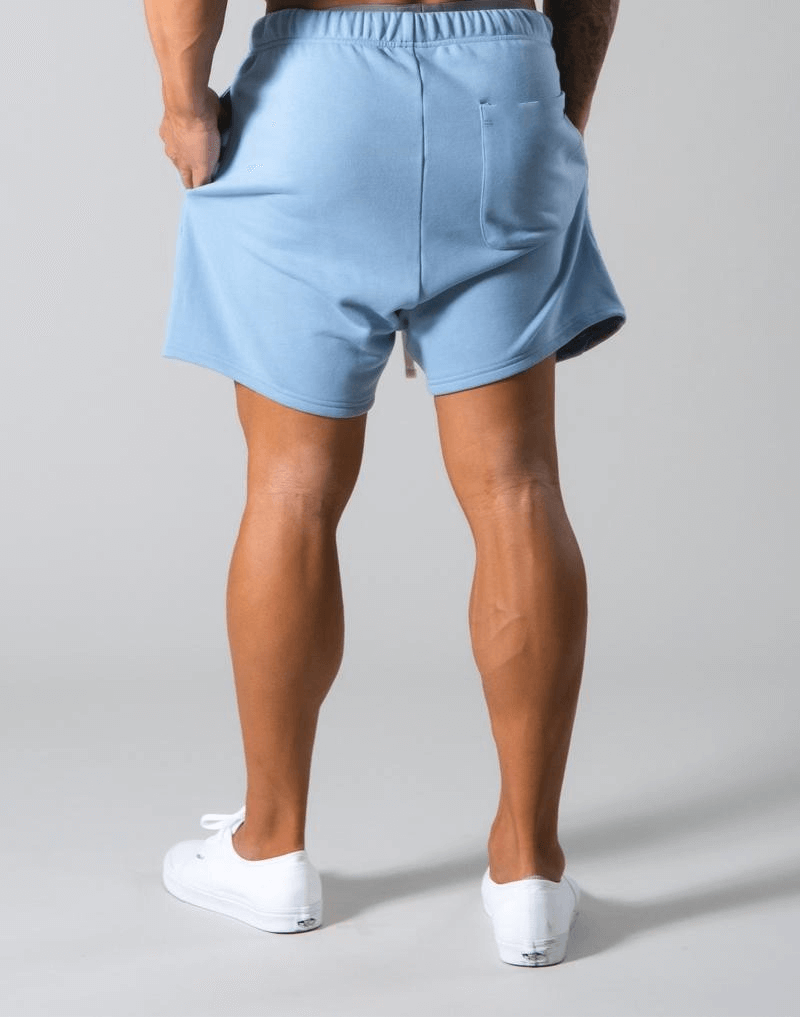 Back view of model wearing blue elastic waist patchwork gym shorts, showcasing comfort and style for active wear