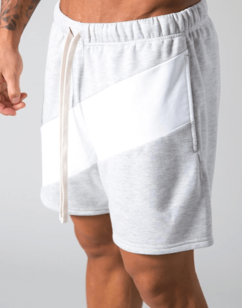 Men's elastic waist patchwork running shorts in grey with side pockets, perfect for gym workouts and running activities.