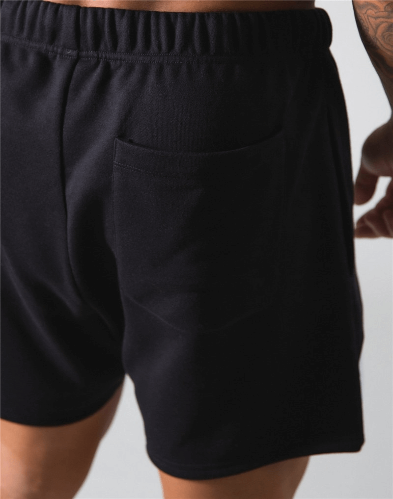 Back view of black elastic waist patchwork running shorts with pocket detail, perfect for gym and sports activities.