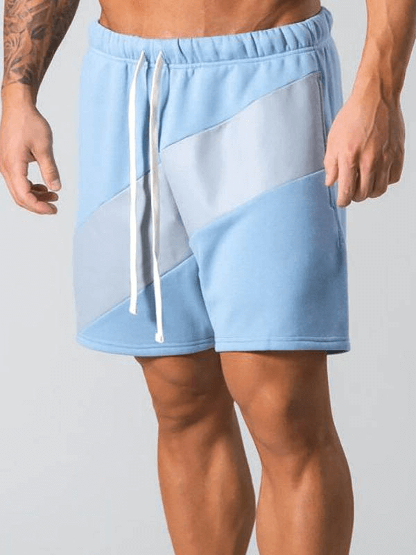 Men's blue elastic waist patchwork running shorts for gym with cotton blend, shown on model. Perfect for workouts and sports.
