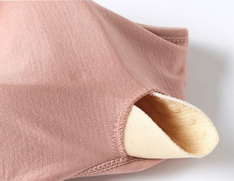 Close-up of pink elastic women's sports bra with zipper and adjustable straps, showing soft interior for comfort and support.