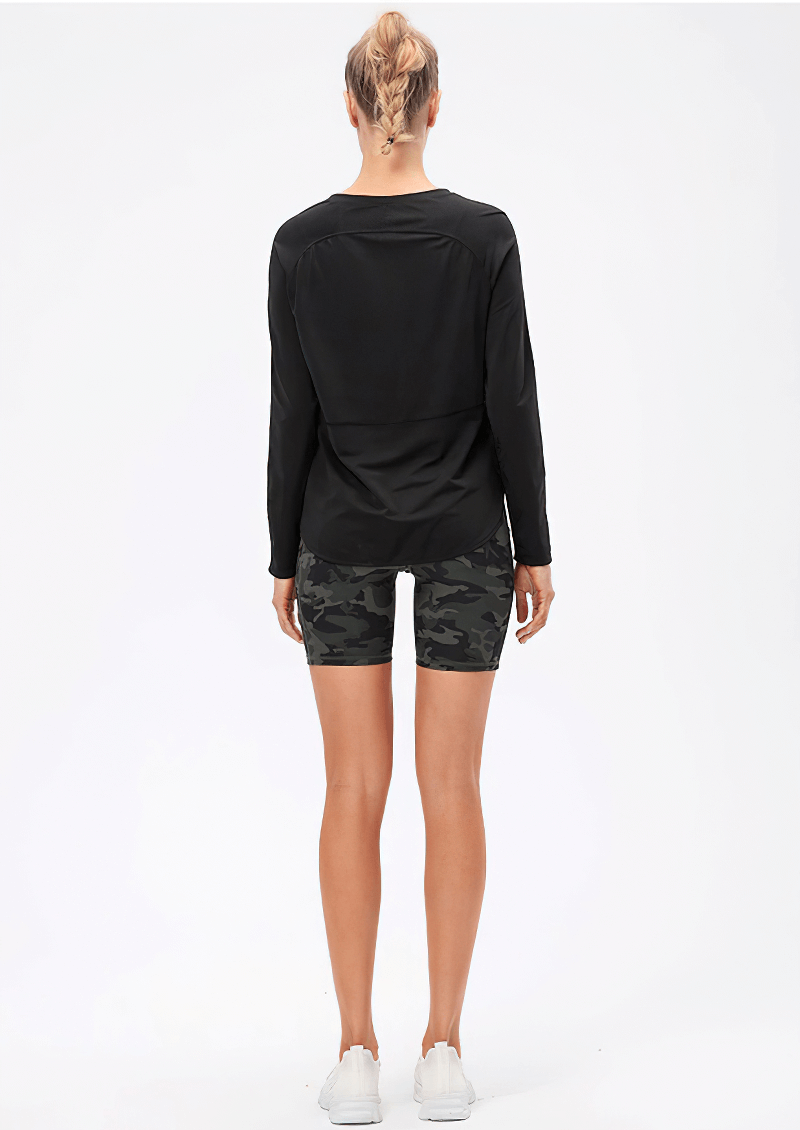 Back view of a woman wearing a black long sleeves sports top with draped hem and camo shorts, perfect for yoga and workouts.